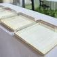 Set of clear plastic trays on a white tablecloth with a blurred outdoor background

